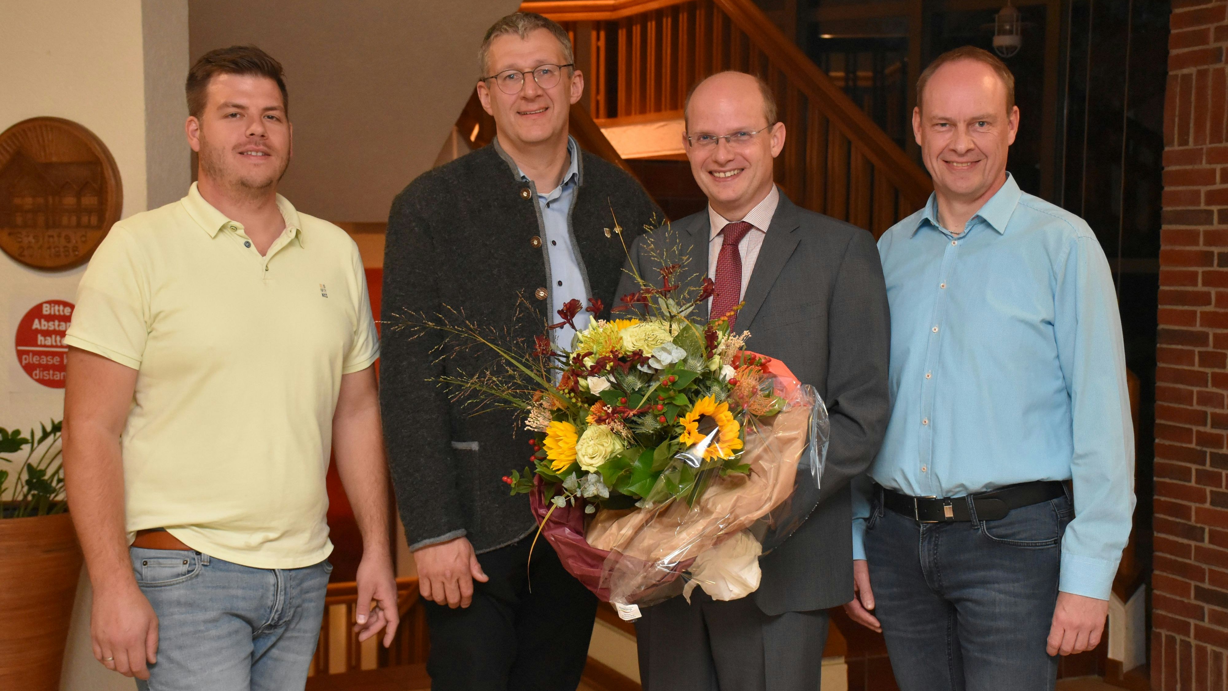 Ein Blumenstrauß für den Wahlsieger: Sebastian Gehrold (2. von rechts) ist neuer Bürgermeister der Gemeinde Steinfeld. Zu den ersten Gratulanten gehörten die Parteispitzen (von links) Lars Beckmann (SPD), Peter Harpenau (CDU) und Christoph Schlarmann (UWG). Foto: Timphaus
