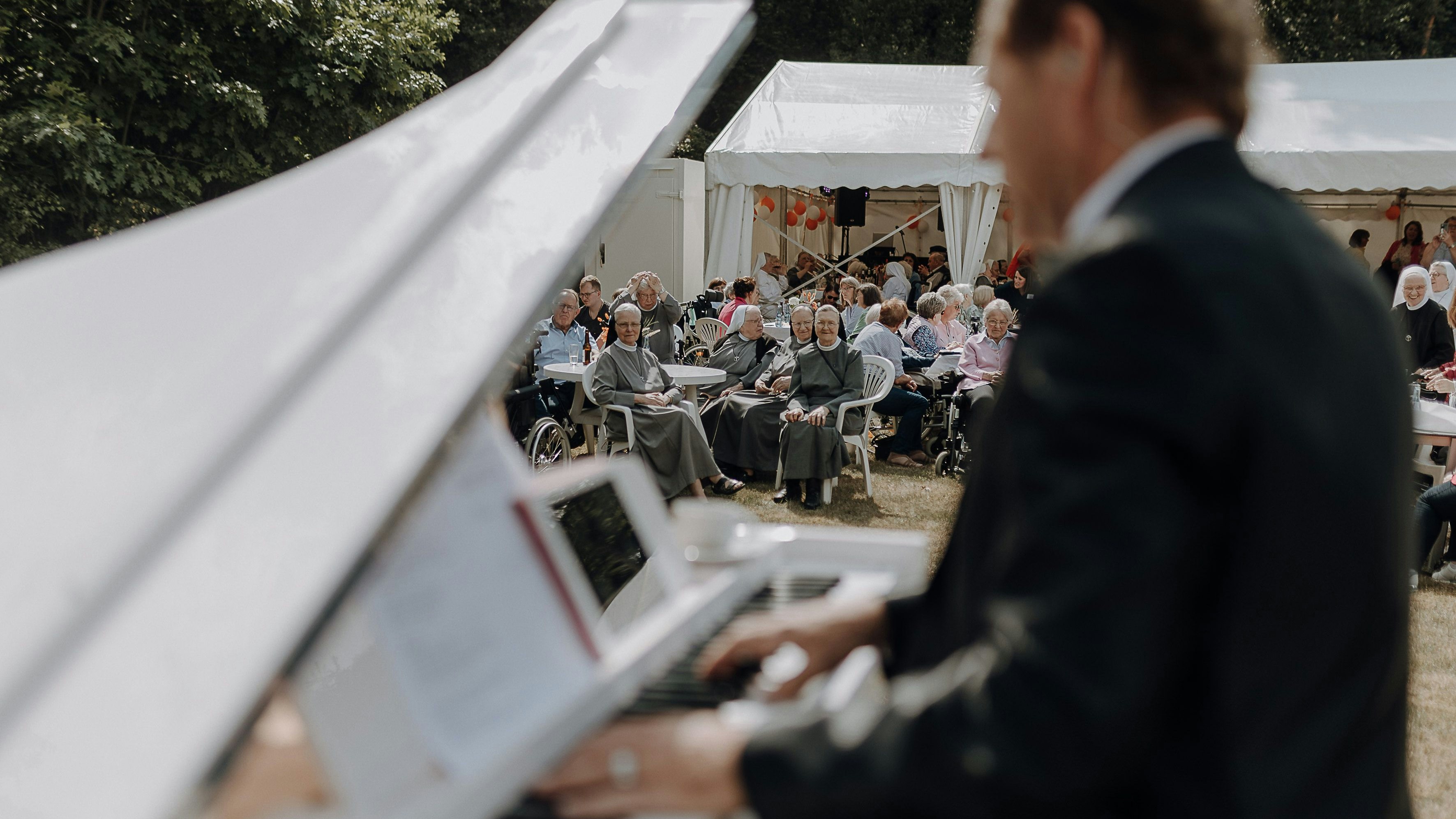 Am weißen Piano und mit weicher Stimme verzauberte „Udo“ die Gäste des Sommerfestes im St. Anna-Stift Kroge. Foto: Thygs