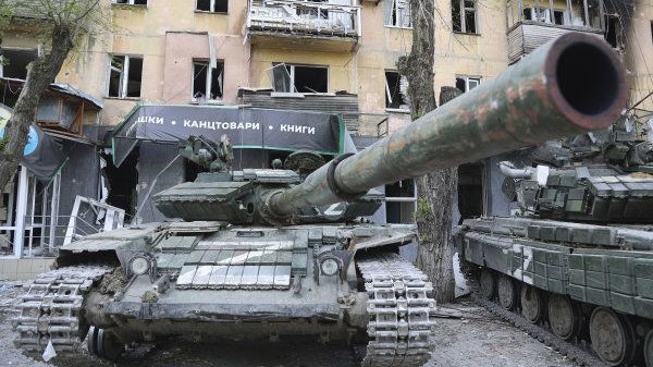 Alltag in Mariupol: Panzer der Miliz der Volksrepublik Donezk neben einem beschädigten Wohnhaus.&nbsp; Foto: dpa/AP/Alexandrov