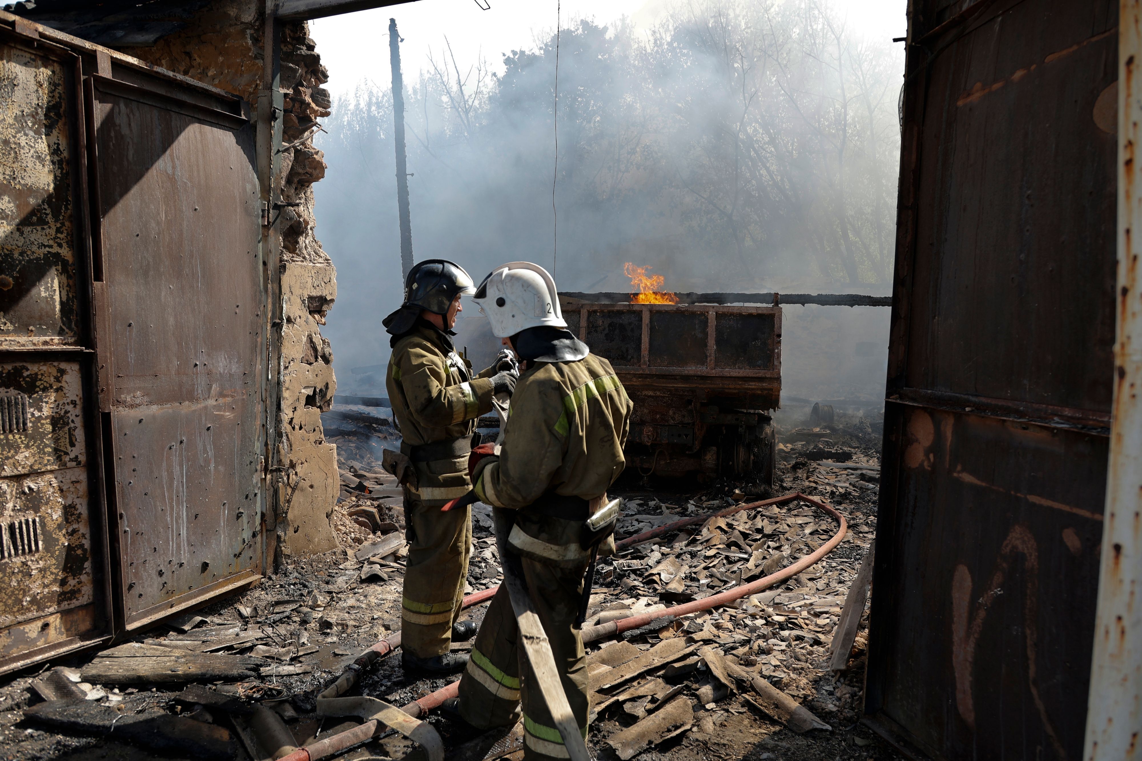 Mitarbeiter des Ministeriums für Notsituationen der separatistischen Donezker Volksrepublik sind nach dem Beschuss des Leninsky-Viertels in Donezk im Einsatz. Foto: dpa/AP/Alexandrov