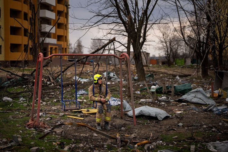 Tschernihiw: Ein Feuerwehrmann sitzt auf einer Schaukel neben einem Gebäude, das durch eine russische Bombe zerstört wurde. Foto: dpaMorenatti
