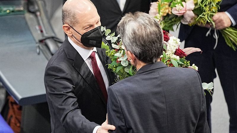 Bundeskanzler Olaf Scholz (l) erhält vom SPD-Fraktionschef Rolf Mützenich einen Blumenstrauß. Foto: Michael Kappeler / dpa