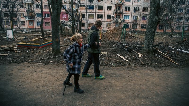 Menschen gehen an einem völlig zerstörten Gebäude in Charkiw vorbei, das von der russischen Armee beschossen wurde. Foto: dpa/Karimov