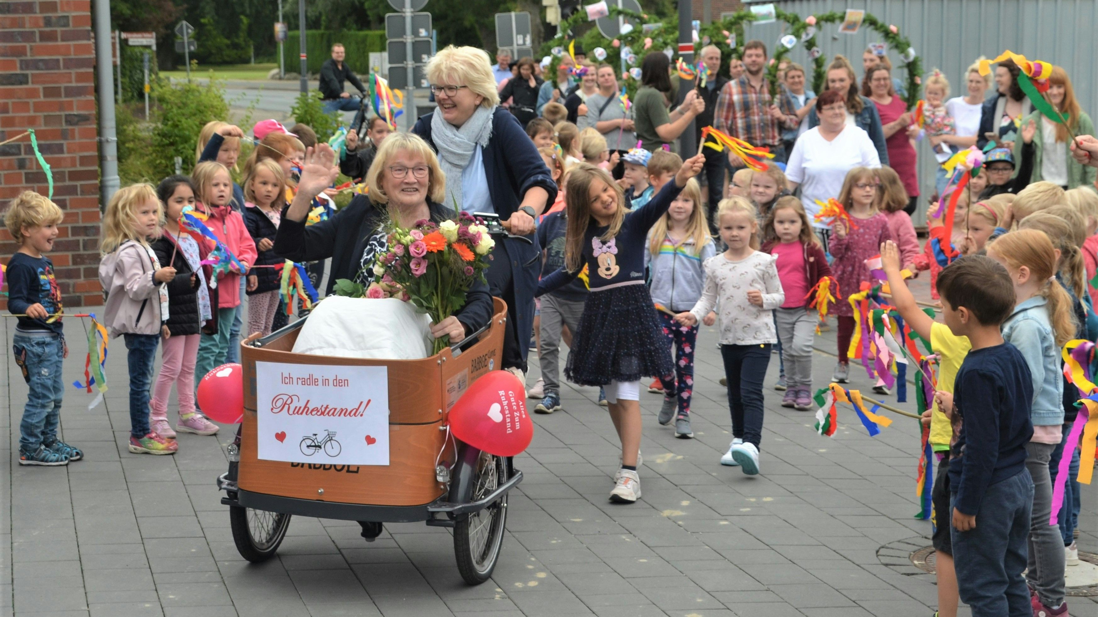 Begleitet von Kindergartenkindern und Eltern ließ sich Agnes Willenborg in den Ruhestand radeln. Foto: Pille