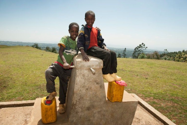 Freude über frisches Wasser: Zwei äthiopische Jungs auf einer neuen Brunnenanlage im Projektgebiet Dano, gebaut von MfM“.